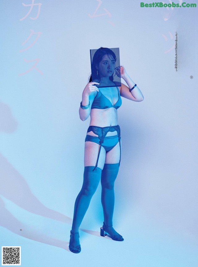 A woman in a blue lingerie holding a mirror.