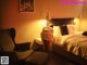 A woman standing in front of a bed in a bedroom.