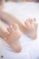 A close up of a person's feet on a bed.