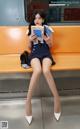 A woman sitting on a bench reading a book.