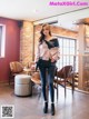 A woman standing in a room with a table and chairs.