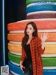 A woman standing in front of a stack of colorful plates.