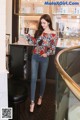 A woman standing in front of a counter holding a drink.