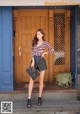 A woman standing in front of a blue door.