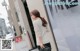 A woman standing in front of a store window holding a purse.