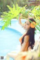 A woman in an orange bikini sitting in a pool.