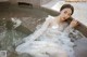 A woman in a white dress sitting in a pool of water.