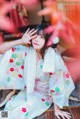 A woman in a kimono sitting on a wooden floor.