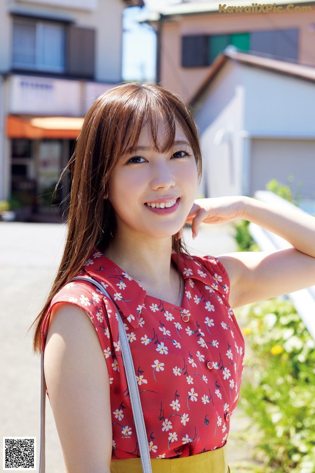 A woman in a red top and yellow skirt posing for a picture.