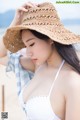 A woman wearing a straw hat on the beach.