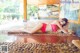 A woman in a red bikini laying on the floor.