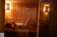 A woman laying on a wooden bench in a sauna.