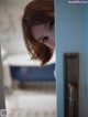 A woman peeking out from behind a blue door.