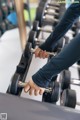 A person holding a pair of dumbbells in a gym.