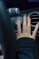 A woman's hand on the gear stick of a car.