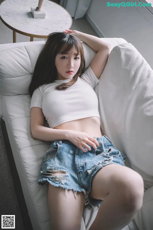 a woman sitting on top of a white couch