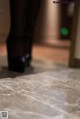 A close up of a person standing on a marble floor.