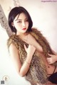 A woman in a fur vest posing for a picture.